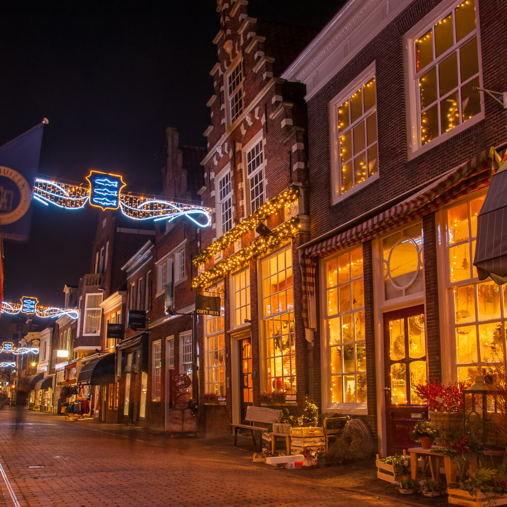 Winkelstraat in de avond met JW Bloemen en Planten en Het Coffy-Huys